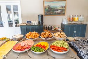 a buffet with bowls of different fruits and vegetables at Hotel Stafholt in Varmaland