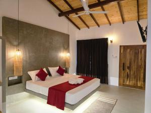 a bedroom with a bed with red pillows at Villa Nutmeg Grove Galle in Galle