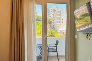 a room with a window with a chair and a table at Zena Hotel Durres in Durrës