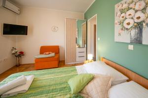 a bedroom with a bed and an orange chair at Guest Accommodation Slapovi Krke in Lozovac +56 photos