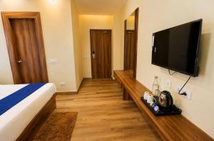 a hotel room with a bed and a flat screen tv at Namastey Puri Hotel - Near Jagannath Dham Temple With Restaurant And Parking Facility Fully Air Conditioning Room in Puri +18 photos