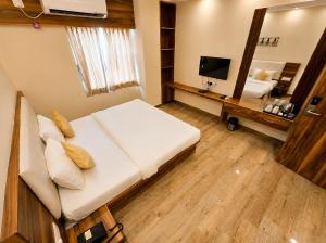 a bedroom with a large white bed and a mirror at Namastey Puri Hotel - Near Jagannath Dham Temple With Restaurant And Parking Facility Fully Air Conditioning Room in Puri