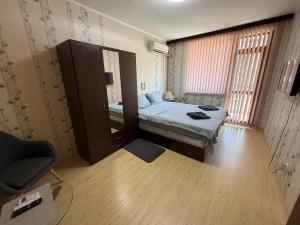 a small room with a bed and a chair at Izgrev Sarafovo in Burgas
