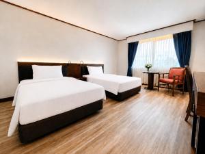 a hotel room with two beds and a chair at AMIS By Sima Thani in Ban Lak Roi +27 photos