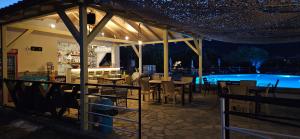 a restaurant with a swimming pool at night at Achillion Hotel in Skala Potamias