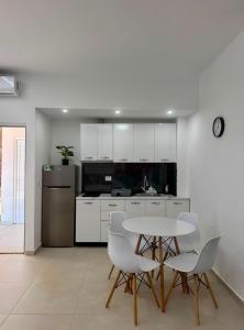 a kitchen with a table and chairs and a refrigerator at Vila Topi in Vlorë