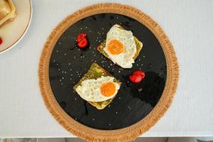a plate with eggs and tomatoes on a table at Lùmar Hotel in Vlorë +16 photos