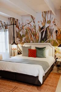 a bedroom with a large bed with a floral wallpaper at Bly B&B in Pretoria