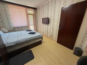 a small bedroom with a bed and a door at Izgrev Sarafovo in Burgas