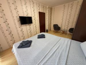 a bedroom with a bed with two blue towels on it at Izgrev Sarafovo in Burgas