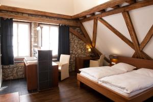 a bedroom with a bed and a desk and windows at Weinhotel Koegler in Eltville