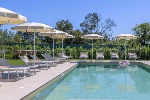 a swimming pool with chairs and umbrellas at Villa Lina in Morrovalle