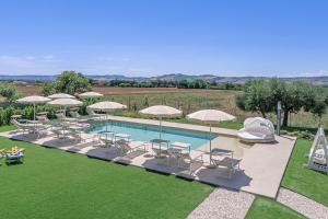 a pool with tables and chairs and umbrellas at Villa Lina in Morrovalle