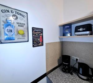 a sign on a wall with a bottle of gin at Henneberger Hof Goldstück in Münnerstadt