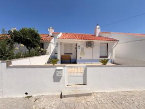 a white house with a white wall and a door at Casa dos Avós in Santa Eulália