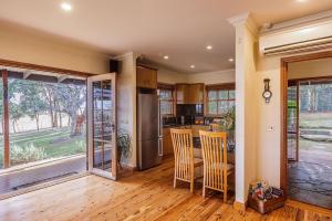 a kitchen with a table and chairs and a kitchen with a window at BullerRoo Luxury Chalet & Cottage Farmstay in Barwite +39 photos