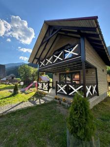 a large building with a porch and a playground at Котедж у Софійки in Synevyrsʼka Polyana