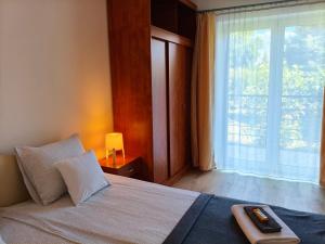 a bedroom with a bed and a large window at Sorompó Vendégház in Balatonkenese