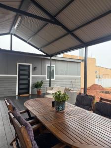 a patio with a wooden table and chairs at Lamington Guesthouse in Kalgoorlie
