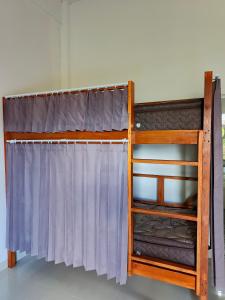 a bunk bed with a purple curtain at Tetebatu Backpackers Base in Selong