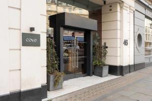 a store front with a revolving door on a street at COVE Cannon Street in London +16 photos