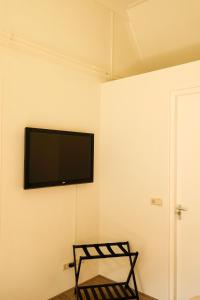 a room with a tv on a wall with a chair at B&B Bistro Lochem in Lochem