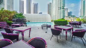 a patio with tables and chairs next to a pool at Novotel Suites at Acqua in Manila