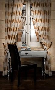 a desk with a chair in front of a window at Luciano Al Porto Boutique in Valletta