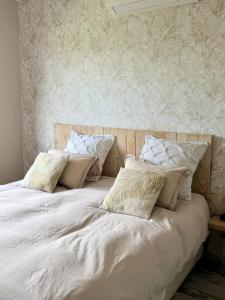 a bed with white sheets and pillows in a bedroom at Chez Marianne in Wailly