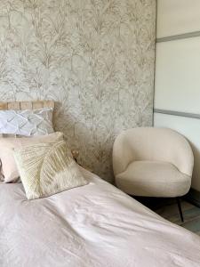 a bedroom with a bed and a chair at Chez Marianne in Wailly