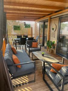 a screened porch with couches and a table and chairs at Mobile Home Drage Tara in Drage
