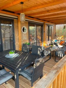 a wooden deck with a black table and chairs at Mobile Home Drage Tara in Drage