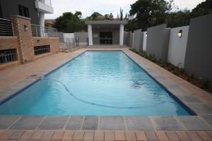 a swimming pool in the backyard of a house at The Hub Apartments Bryanston in Johannesburg