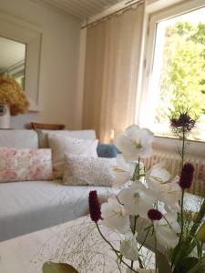 a living room with a couch and a vase of flowers at Ferien am See in Möhnesee
