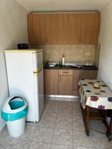 a small kitchen with a table and a refrigerator at Villa Maria in Mángana +8 photos