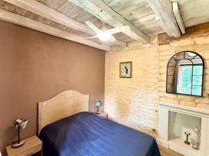 a bedroom with a blue bed and a brick wall at Le Moulin Aux Ans in Archignac +96 photos