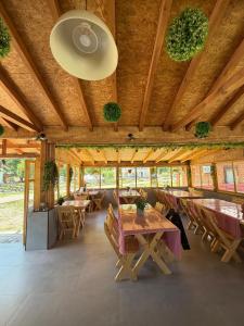 a dining room with wooden tables and wooden ceilings at Riverside - Mountain Stay with Sauna in Vusanje