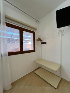a living room with a tv and a window at Hill Suites in Vlorë