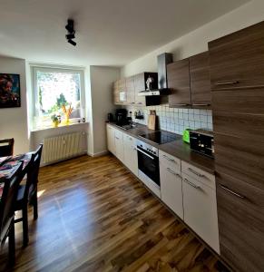 a kitchen with wooden floors and a table and a kitchen with a counter at Henneberger Hof Wildlife in Münnerstadt