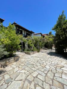 a stone patio in front of a house at Saily Beach Hotel in Koropi