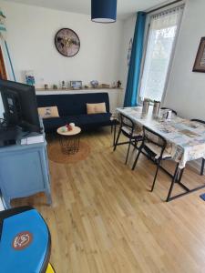 a living room with a blue couch and a table at Les flots d'Émilie et Vincent in Barneville-Carteret