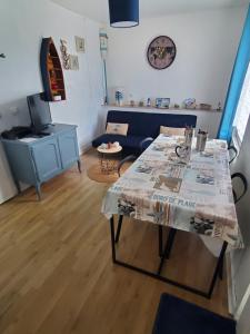 a living room with a table and a couch at Les flots d'Émilie et Vincent in Barneville-Carteret