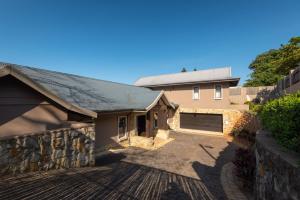 a house with a garage and a stone wall at Stella Road 24 in Ballito