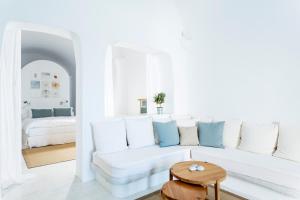 a white living room with a white couch and a table at Helestia Hotel, Caldera Santorini in Firostefani