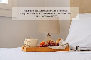a tray of fruit and bread on a bed at Sanders Paros Gardens in Molos Parou