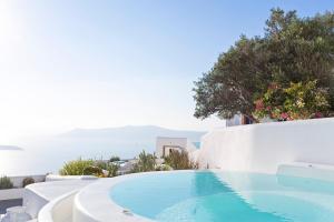 a swimming pool on the side of a villa at Helestia Hotel, Caldera Santorini in Firostefani