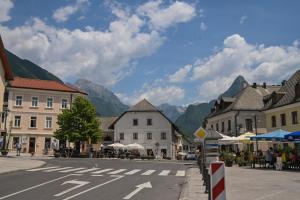 a street in a town with mountains in the background at Počitniško stanovanje Aurora in Bovec