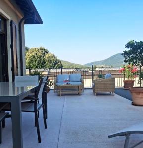 a patio with couches and a table and chairs at Villa Italia in Canzo