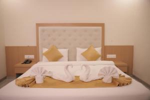 a bedroom with a bed with two towels on it at Hotel Rangoli - 10 min from Palsana chowk in Navsāri +51 photos