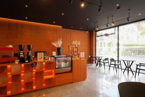 a restaurant with a tv and tables and chairs at AMIS By Sima Thani in Ban Lak Roi
